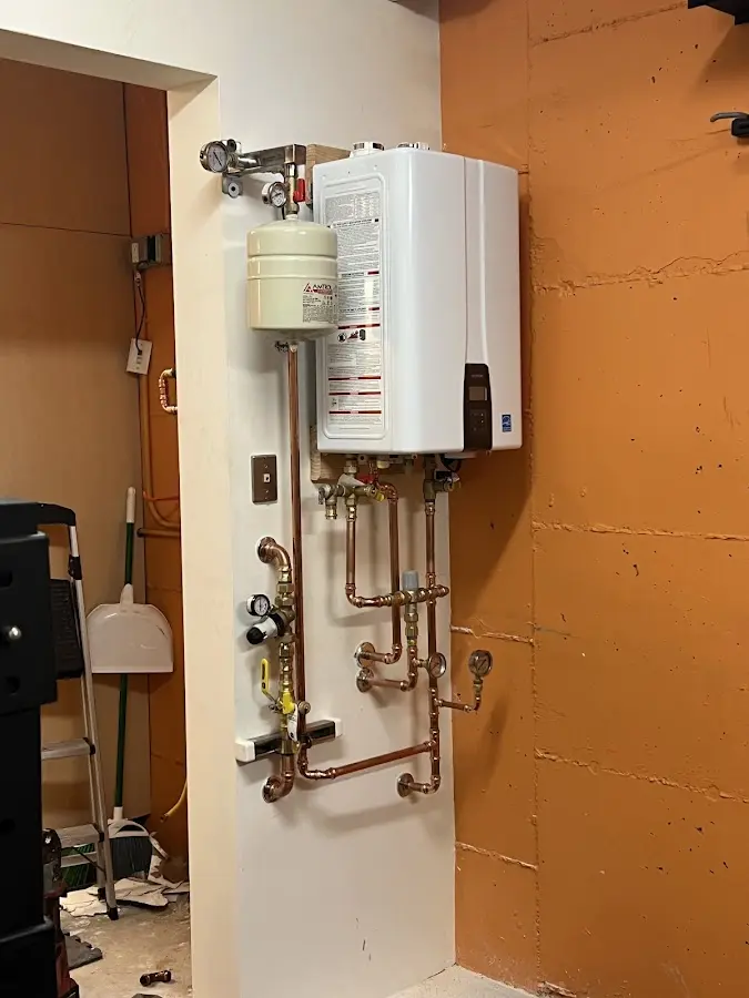 Plumbing technician inspecting water heater connections in Coeur d'Alene